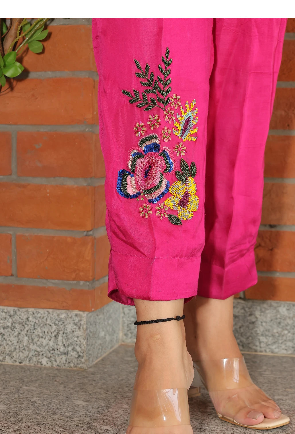 the Empress Embellish from Destiny by Anjali, a striking designer coord set in hot pink. Crafted from luxurious bombarg satin fabric, this outfit features exquisite hand-embroidered floral beaded designs on the shoulders, adding a regal touch. Fully lined for comfort, this set is ideal for all-weather wear. Perfect for both casual and formal events, this trending piece of western wear combines elegance and style, making it perfect for all occasions and a must-have in your wardrobe.
