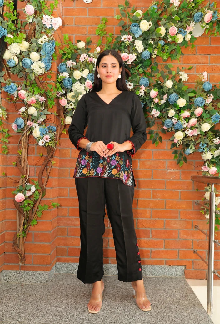 the Empress Ebony coord set from Destiny by Anjali. This designer western wear features a sleek black tone, crafted from luxurious bombarg satin fabric. The shirt is beautifully adorned with intricate zardozi hand embroidery at the bottom, giving it an elegant, floral touch. Perfect for all-weather and occasion wear, this trending coord set blends timeless tradition with contemporary style, making it a must-have for any wardrobe. Elevate your look with this chic and versatile set for any occasion.