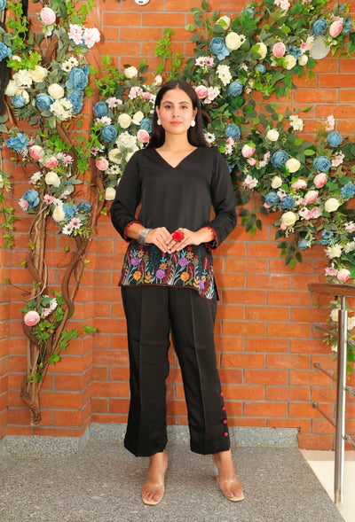 the Empress Ebony coord set from Destiny by Anjali. This designer western wear features a sleek black tone, crafted from luxurious bombarg satin fabric. The shirt is beautifully adorned with intricate zardozi hand embroidery at the bottom, giving it an elegant, floral touch. Perfect for all-weather and occasion wear, this trending coord set blends timeless tradition with contemporary style, making it a must-have for any wardrobe. Elevate your look with this chic and versatile set for any occasion.